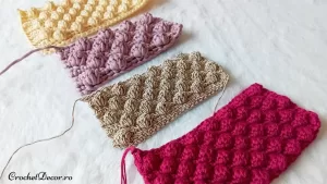 Buna ziua! Sunt Marina de la crochetdecor.ro. Zilele trecute am primit următoarea solicitare de la o clientă: ce fir subţire îi recomand pentru genţi şi se potriveşte a fi croşetat cu modelul bobiţe sau zmeurică cum se mai regăseşte la noi. Doamna dorind să înlocuiască soluţia pe care o folosea: firul Alize Diva Silky Effect pus în 3. Aşa că m-am pus pe treabă şi am realizat eşantioane. Modelul de bobiţe presupune croşetarea împreună a unui grup de 3-5 picioruşe mari. Pentru eşantionalele realizate am folosit un multiplu de patru ochiuri care se repetă: "1 bobită, 3 picioruşe scurte". Bobiţa am realizat-o lucrând 4 picioruşe mari închise împreună.